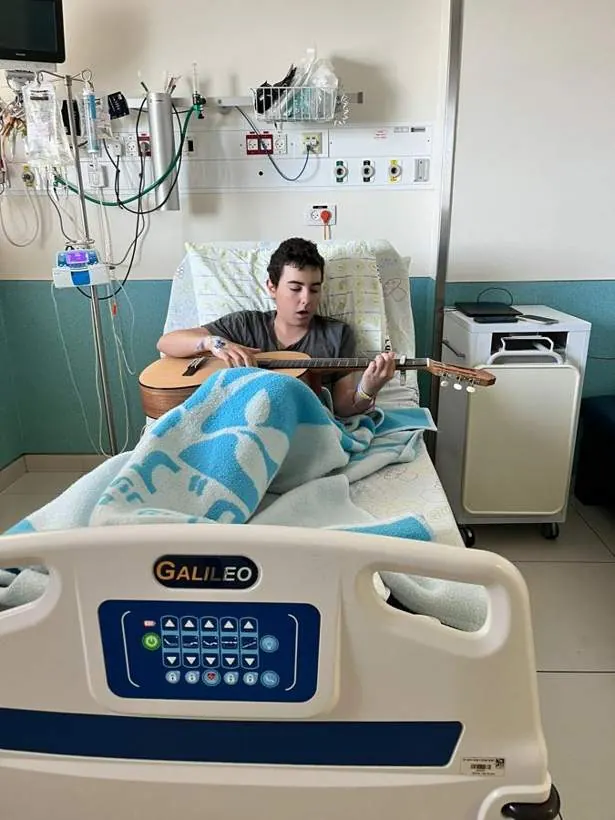 עומר מנגן בגיטרה במיטת בית החולים